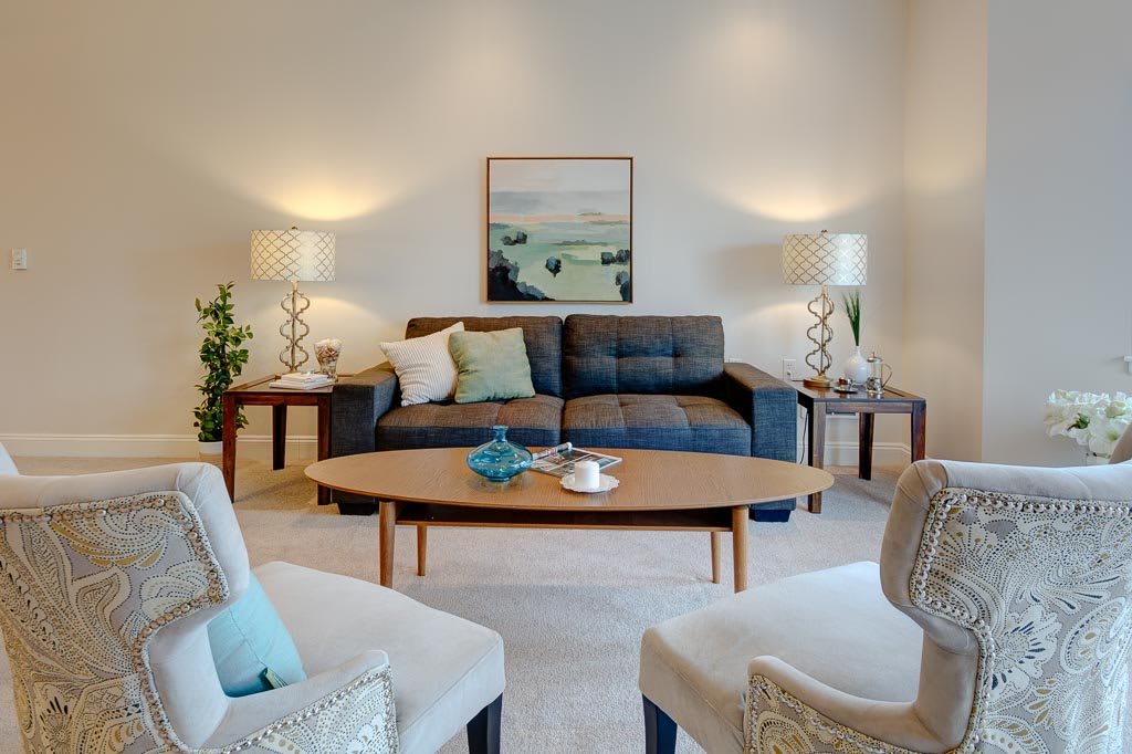 A cozy and stylish living room featuring a modern sofa, wooden coffee table, and warm lighting.