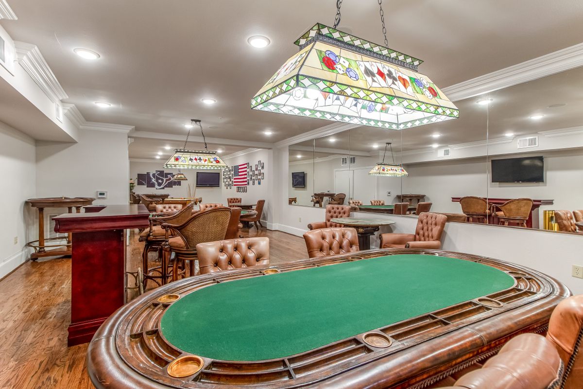 A luxurious gaming room featuring a poker table and elegant seating.