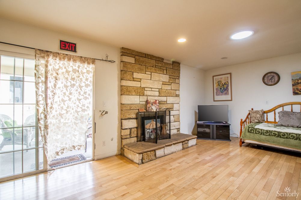 A cozy living room with a stone fireplace and modern decor.