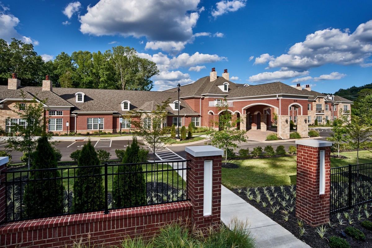 A beautifully designed residential building under a vibrant sky with scattered clouds.