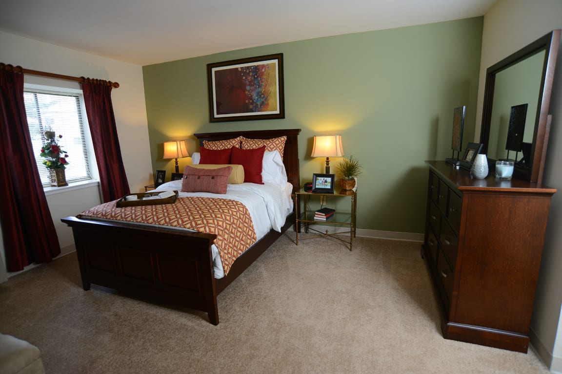 A cozy bedroom with elegant furniture and warm lighting.
