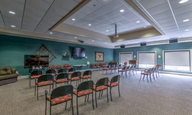 A spacious conference room set up with chairs facing a television screen, ideal for meetings and presentations.