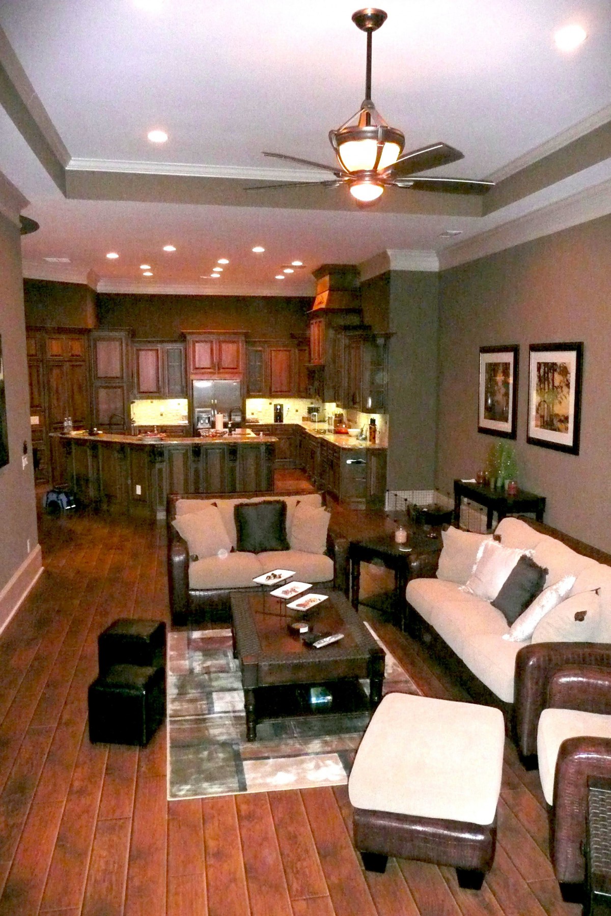 A modern open-concept living room and kitchen with stylish furniture and wood flooring.