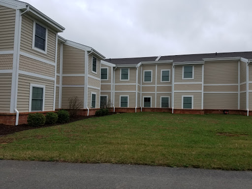 A residential building with a well-maintained lawn under a cloudy sky.