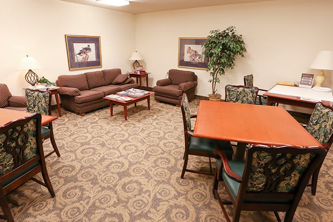 A cozy living room with brown couches, a coffee table, and a dining area.