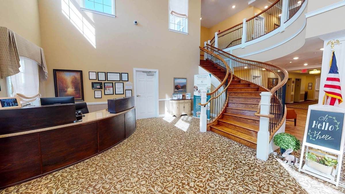 A welcoming lobby area featuring a curved wooden staircase and a reception desk.