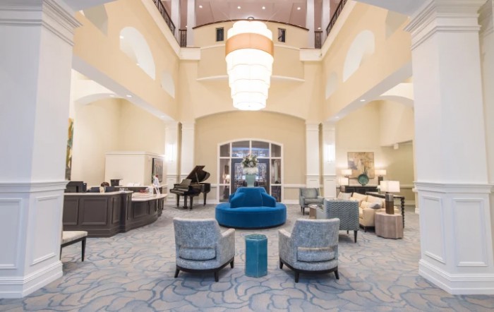 A spacious and elegant hotel lobby with luxurious furnishings and a grand chandelier.