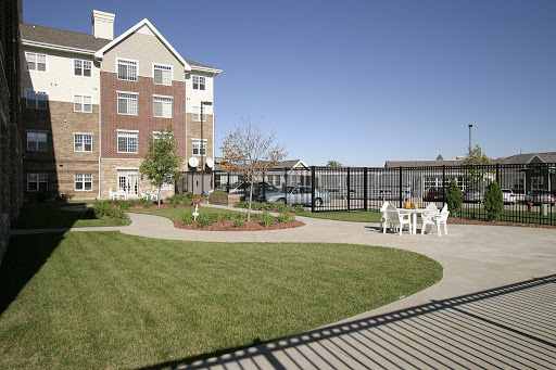 A peaceful outdoor space in an apartment complex featuring well-maintained gardens and seating areas.