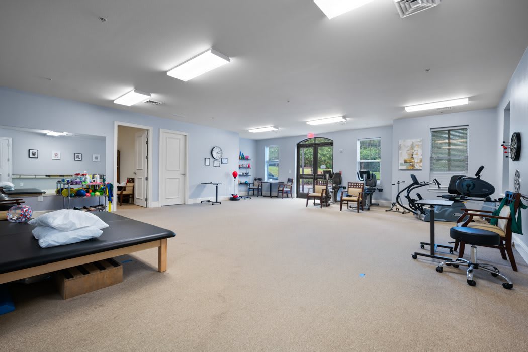 A spacious and well-lit exercise room equipped with gym equipment for fitness or therapy sessions.