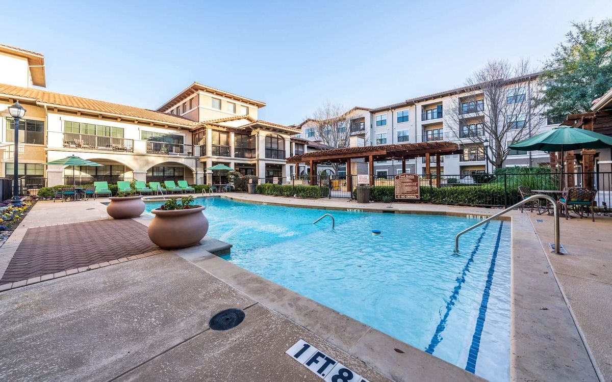 A modern residential complex with a refreshing outdoor swimming pool and patio area.