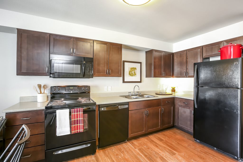A modern kitchen with dark cabinets and sleek appliances.