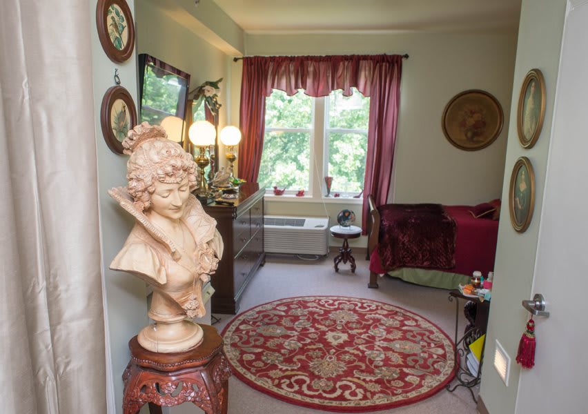 A cozy living room with classical decor, featuring a bust sculpture and elegant furnishings.