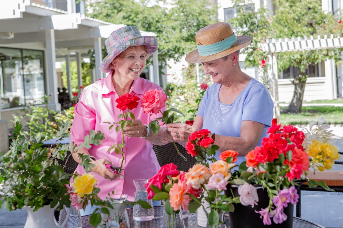 Two women enjoying a day of gardening and arranging flowers outdoors.