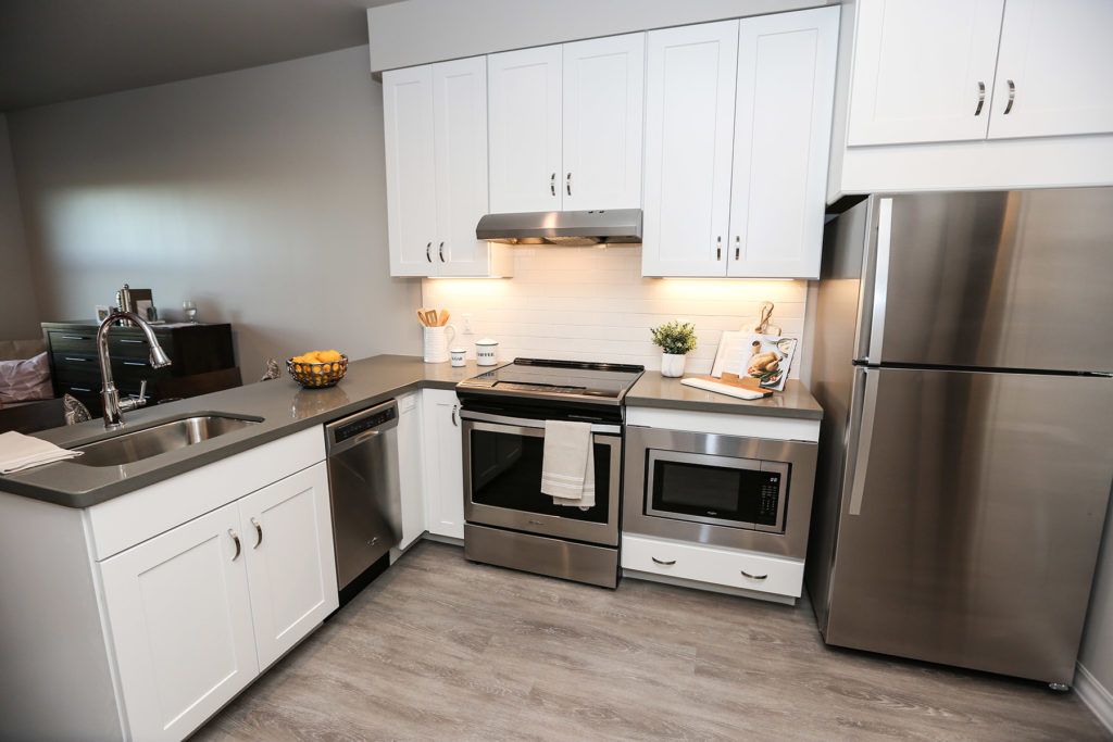 A modern kitchen with stainless steel appliances and white cabinets.