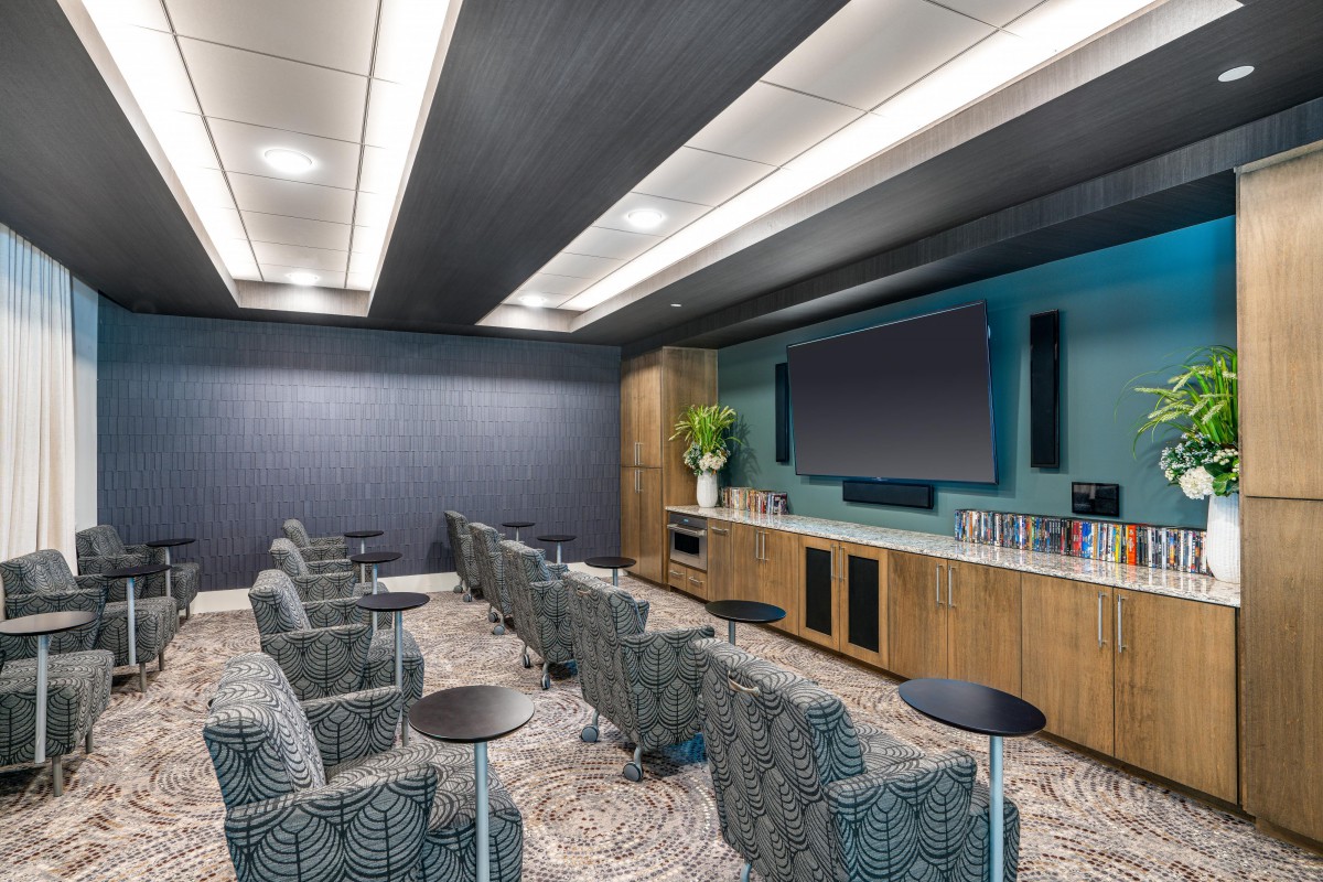 A modern home theater with plush seating and a large screen.