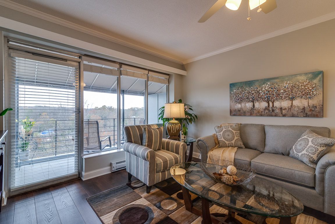 A cozy living room with modern furniture and large windows allowing natural light.