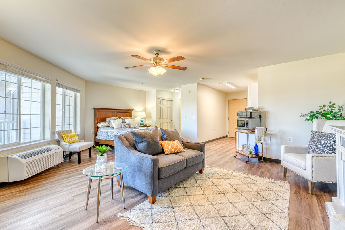 A modern and cozy bedroom with a living area featuring stylish furniture and abundant natural light.