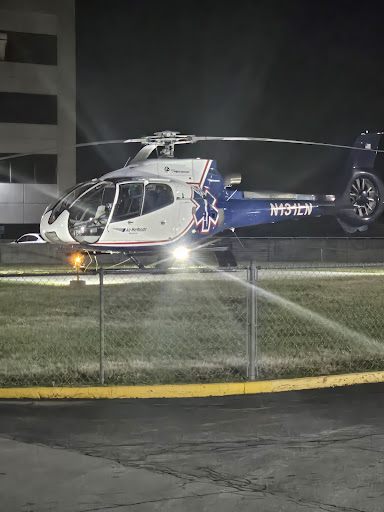 A helicopter preparing for takeoff on a landing pad at night.