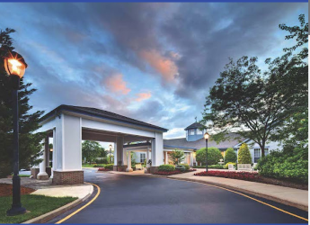 A welcoming entrance to a hospitality venue under a scenic evening sky.