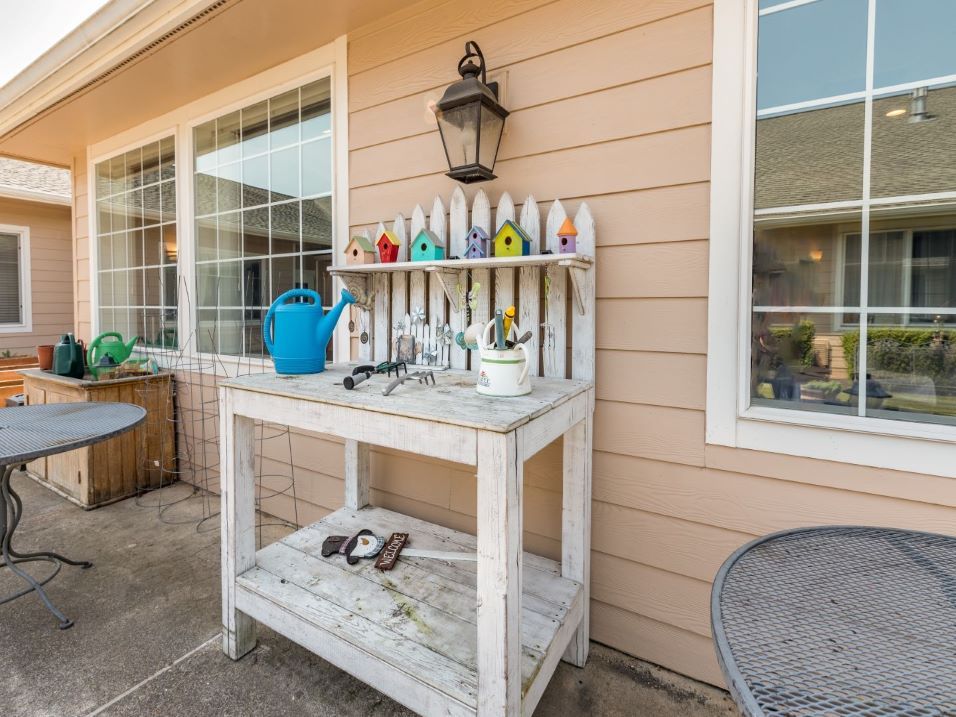 A charming outdoor potting bench adorned with colorful birdhouses and gardening tools on a sunny patio.