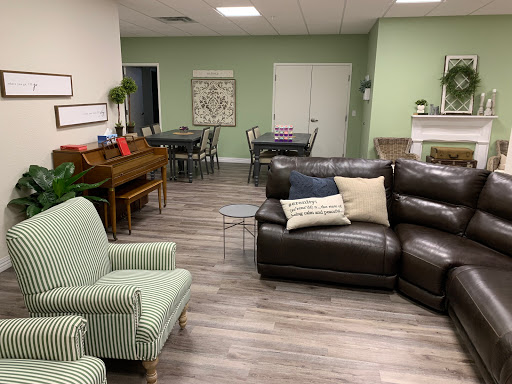 A cozy living room and dining space featuring comfortable seating, a piano, and a warm color palette.