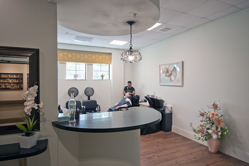 A modern salon interior with a hairdresser attending to a customer.