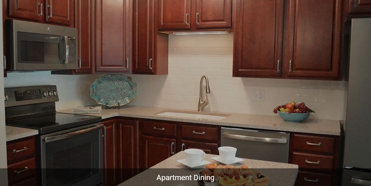 A modern apartment kitchen with wooden cabinets and a sleek sink area.