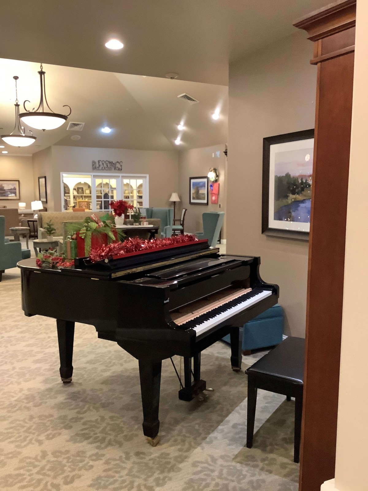 A beautifully decorated living room featuring a grand piano and artwork on the walls.