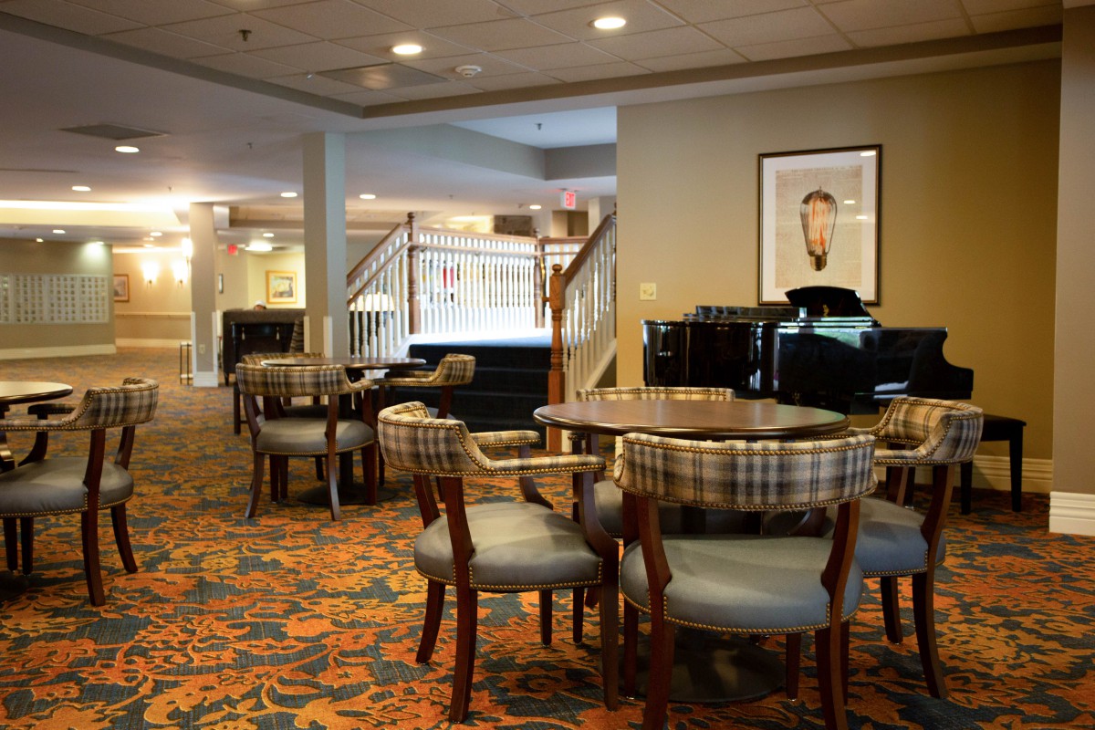 A cozy hotel dining area with seating arrangements and warm lighting.
