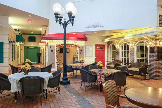 A cozy indoor cafe setup with tables and chairs under decorative street lamps, creating a charming ambiance.