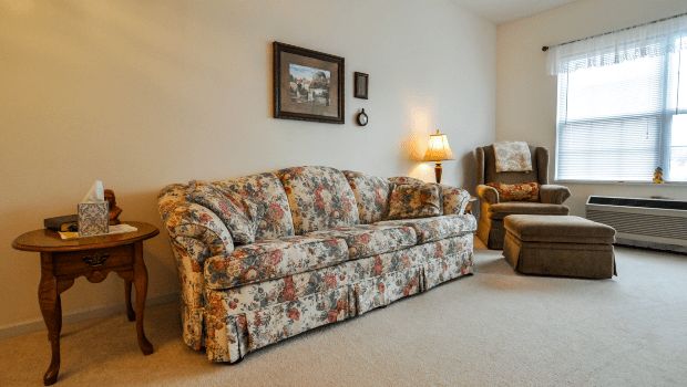 A cozy living room with a floral-patterned sofa and warm lighting.