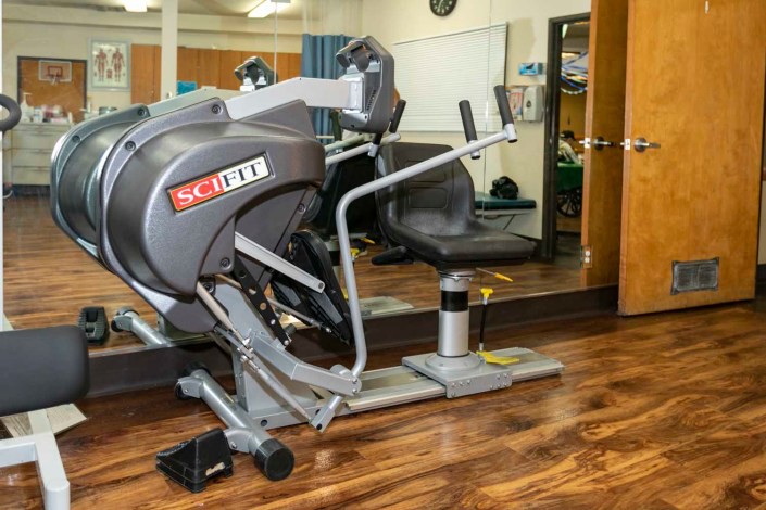 A gym room featuring exercise equipment and a large mirror.