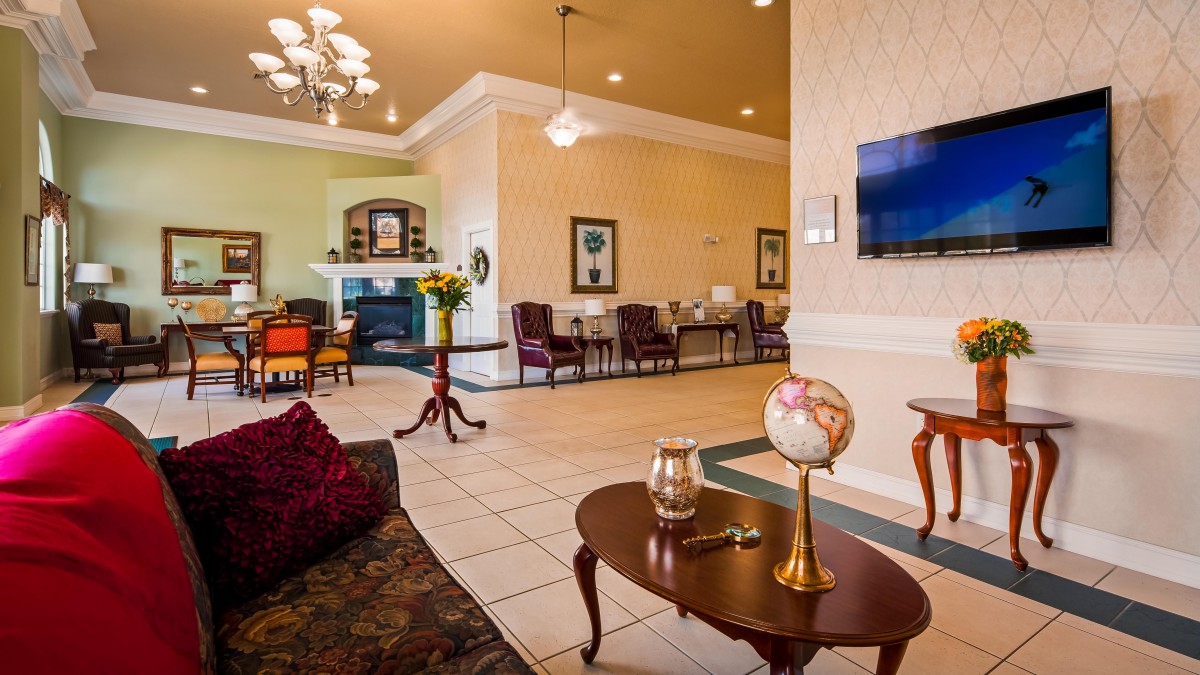 Spacious and elegantly decorated lobby with seating area and chandelier.