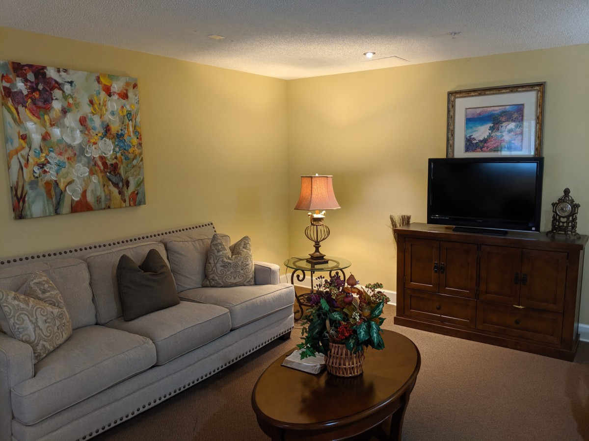 A cozy living room with a sofa, lamp, TV, and decorative elements.