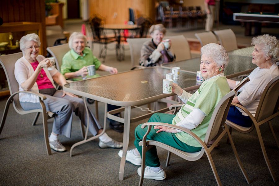 A group of seniors enjoying coffee together at a table indoors.