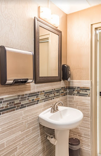 A well-designed bathroom featuring a modern sink, mirror, and hand dryer.