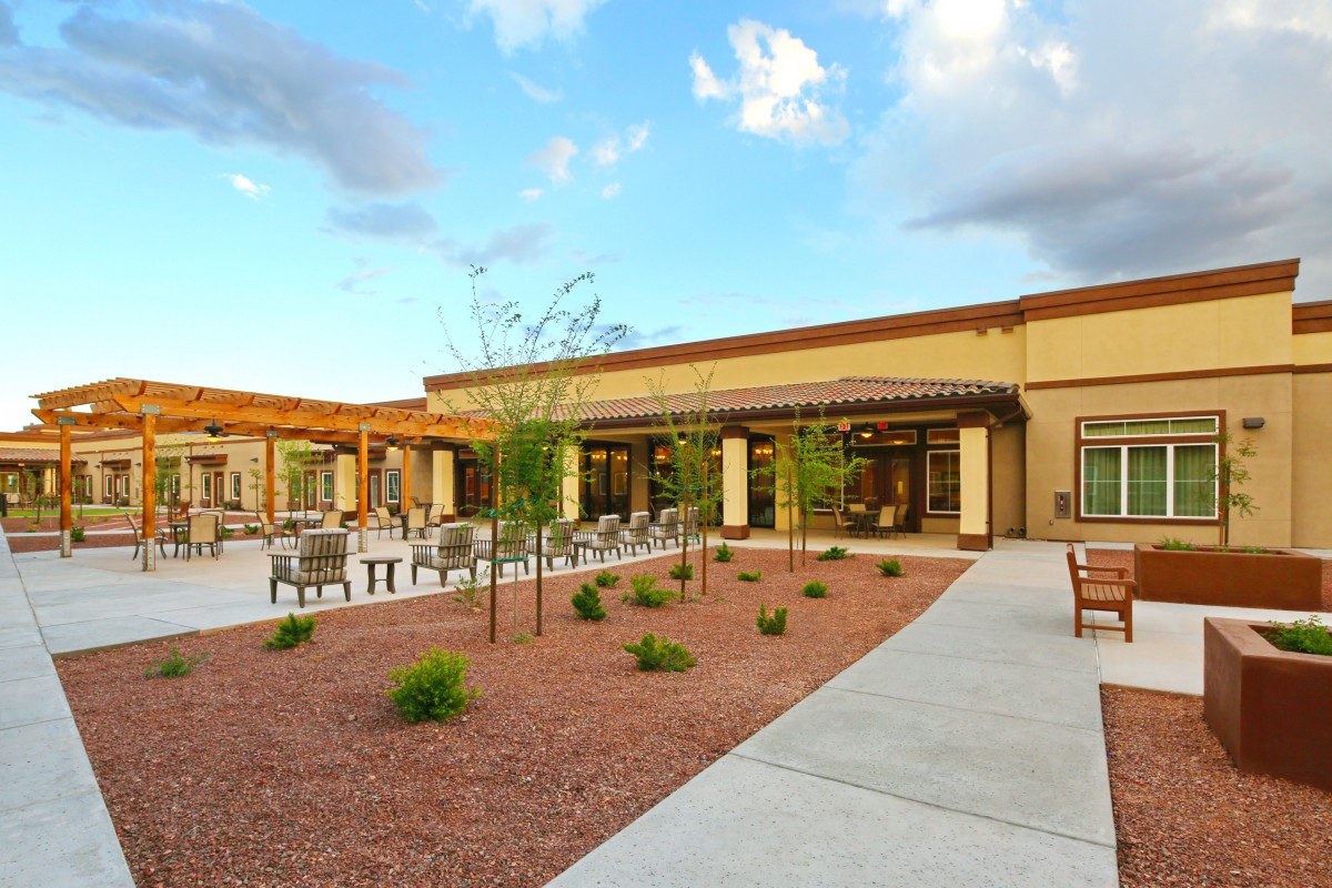 A spacious courtyard with seating and landscaped areas outside a modern building.