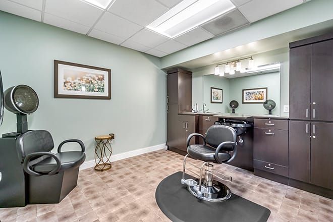 A well-organized hair salon station featuring a styling chair and a large mirror.