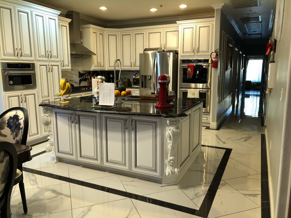 A luxurious modern kitchen with white cabinets and a central island.