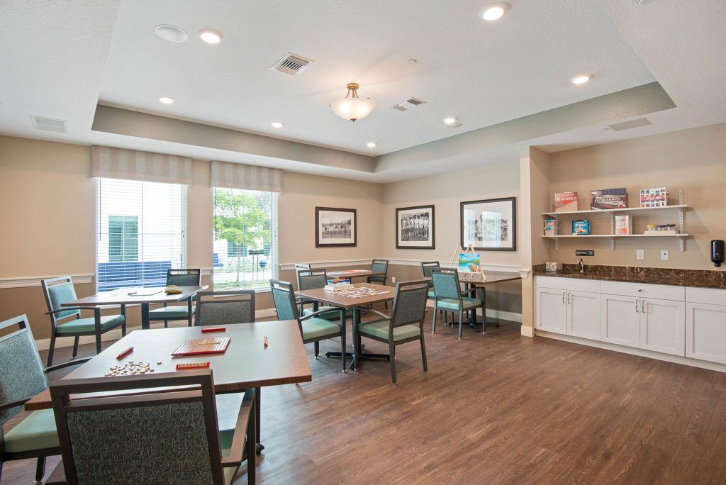 A well-lit dining area with tables and chairs, featuring a hardwood floor and decor on the walls.