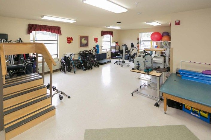 A rehabilitation room equipped with various exercise and physical therapy equipment.