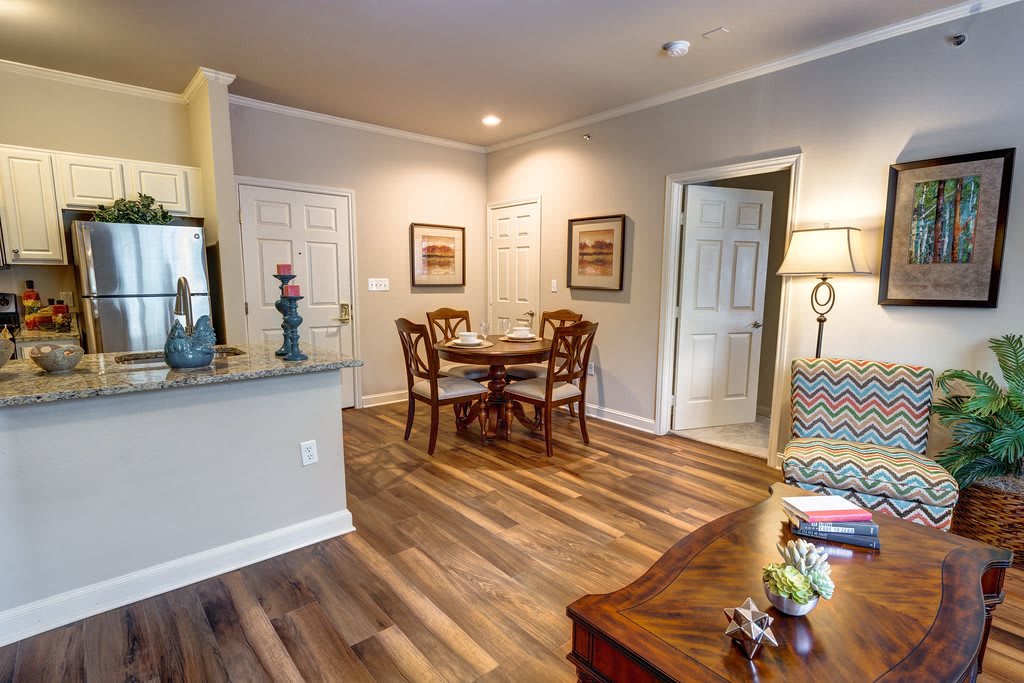 A cozy living space featuring a small dining area with a wooden table and chairs, complemented by warm hardwood flooring.