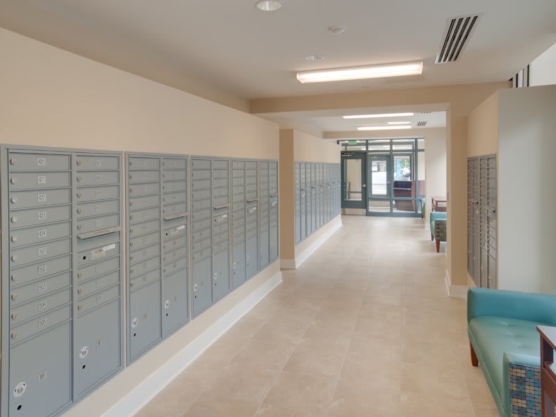 A hallway lined with mailboxes and lockers in a mailroom.