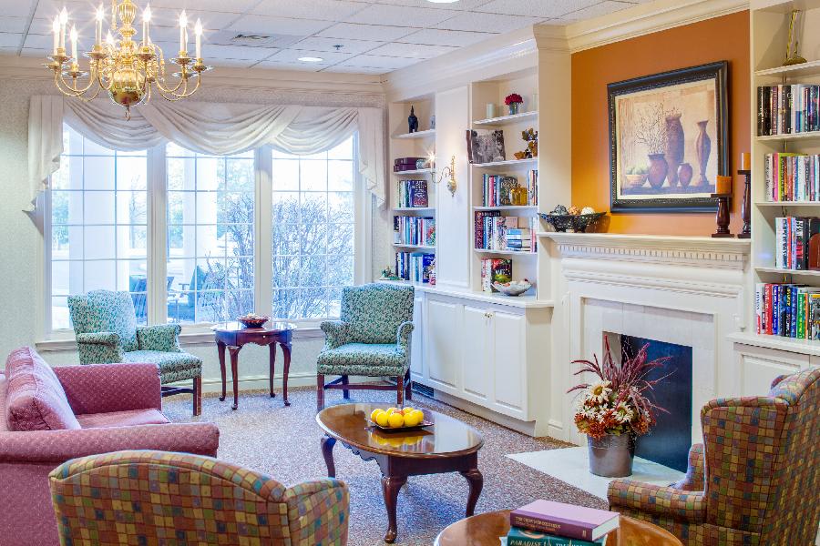 A cozy living room with a fireplace, bookshelves, and comfortable seating.
