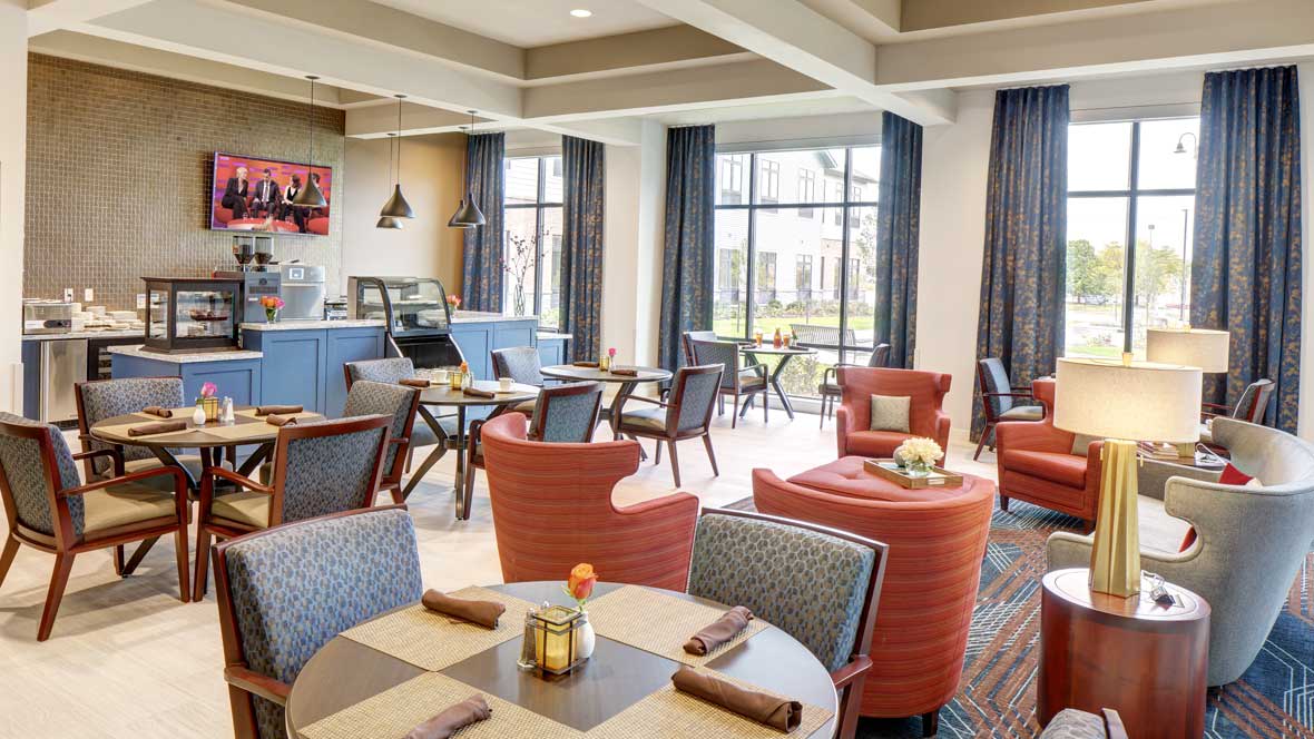 A cozy cafe interior with comfortable seating and large windows.
