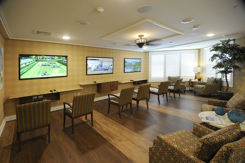 A spacious lounge area with multiple screens and comfortable seating.
