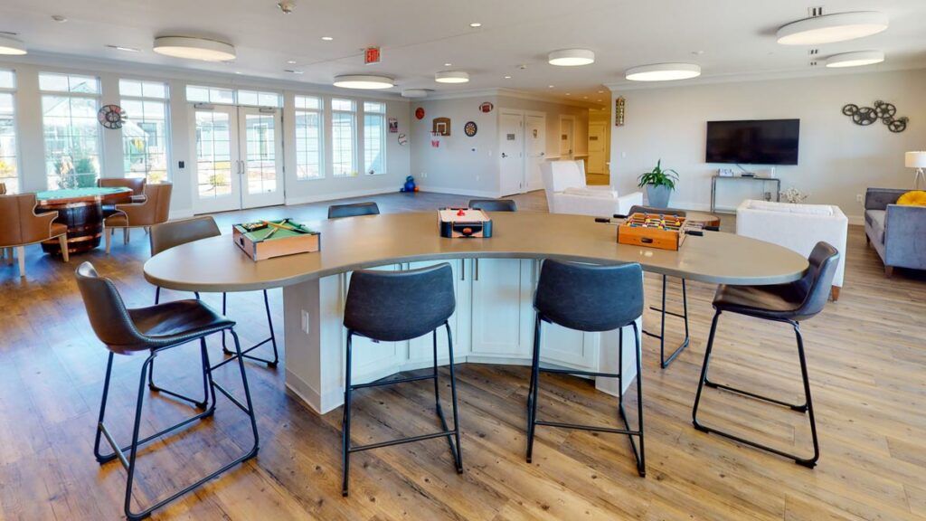 A modern kitchen with an island counter and bar stools, featuring a spacious open layout and wooden flooring.
