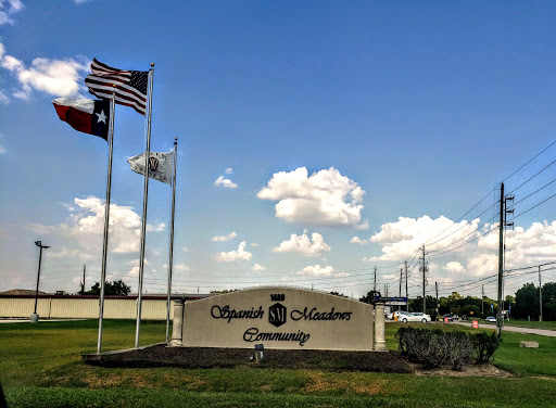 A view of the Apache Junction entrance sign with flags waving under a clear blue sky.