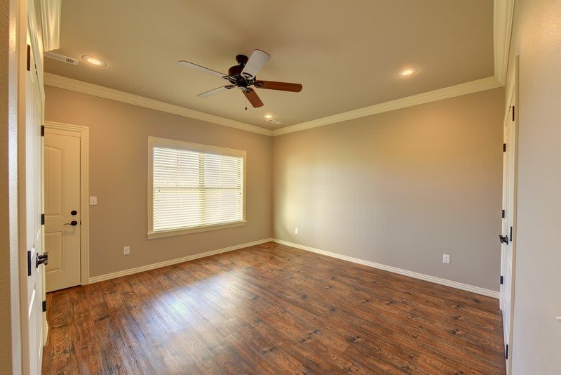 An empty room featuring hardwood floors, a ceiling fan, and recessed lighting.