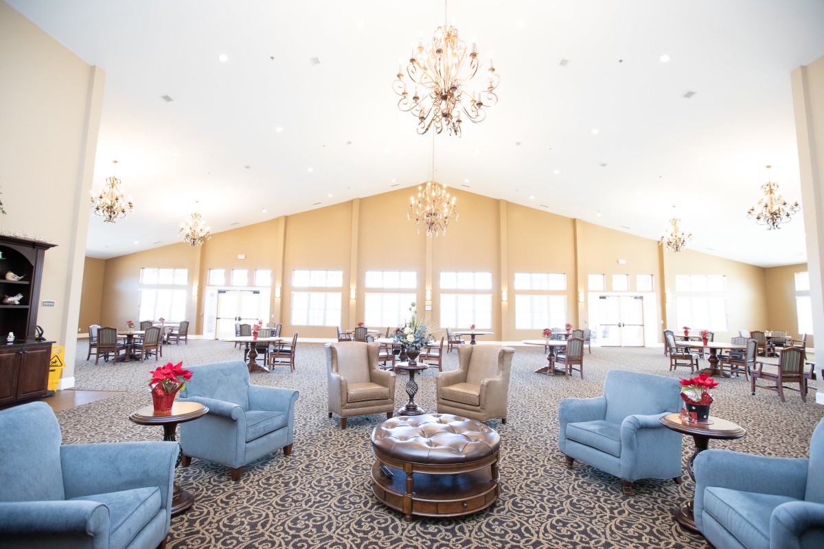 A spacious lounge area with comfortable seating and elegant chandeliers.